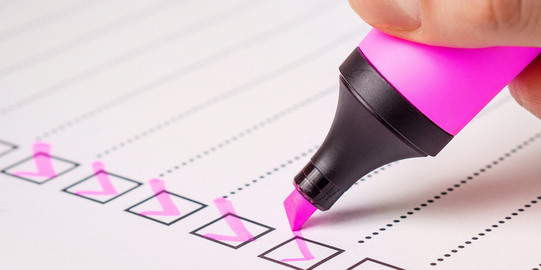 Eine Checkliste wird mit einem Stift abgehakt.