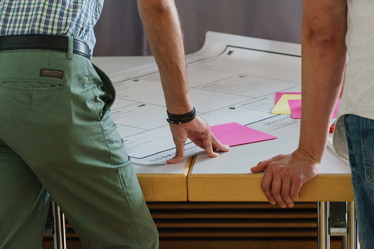 Personen stehen an einem Tisch und es liegen Post-It's darauf